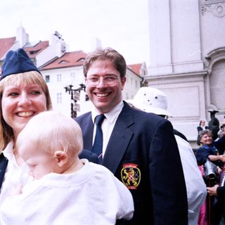 Family posing at outdoor public event.