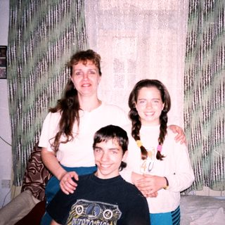 Family posing indoors with a birthday cupcake.
