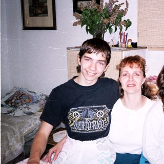 Family photo with three smiling individuals indoors.