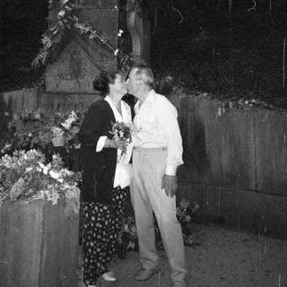 Couple sharing affectionate moment near statue.