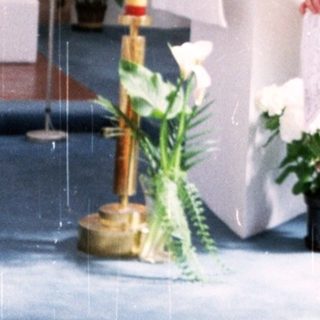 Woman in red standing at church altar.