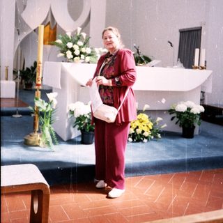 Woman holding prayer book in modern church.
