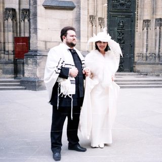 Jewish wedding ceremony outside historic building.