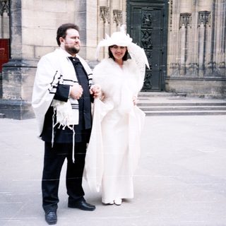 Jewish wedding ceremony outside historic building.