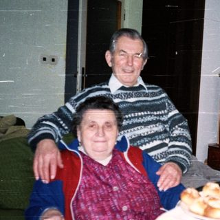 Elderly couple enjoying pastries indoors together.