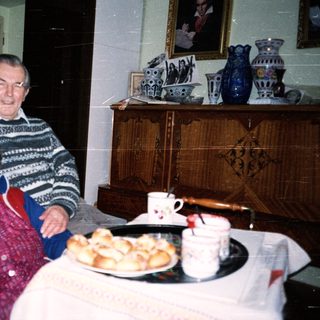 Elderly couple enjoying pastries indoors together.