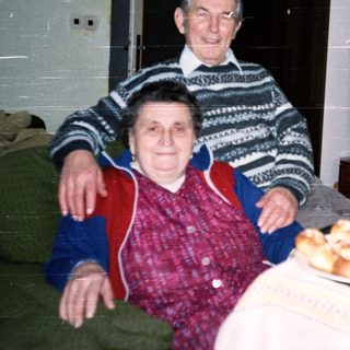 Elderly couple enjoying pastries indoors together.