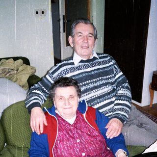 Happy elderly couple enjoying pastries indoors.