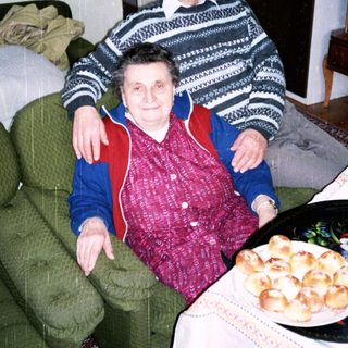 Happy elderly couple enjoying pastries indoors.