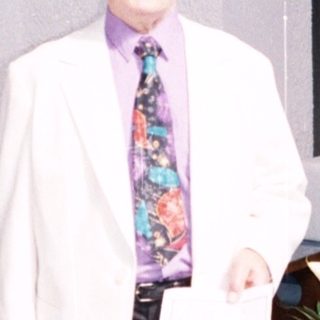 Man in white coat standing in church.