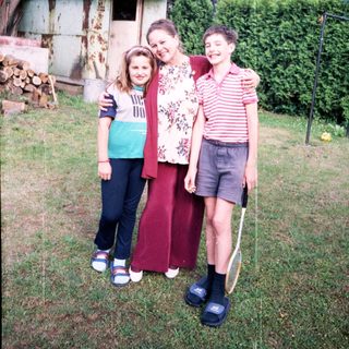 Family posing together outdoors in backyard.