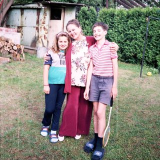 Family posing together outdoors in backyard.