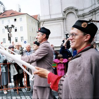 People holding Czech flag in public celebration.
