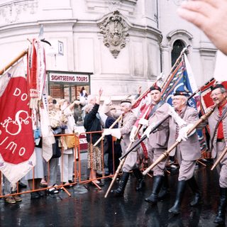 Traditional folk dancers performing with flags outdoors.