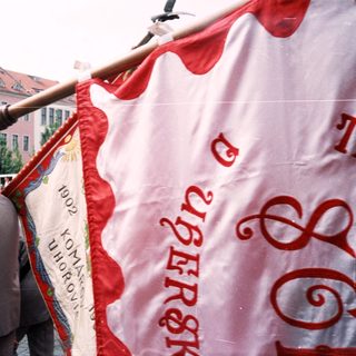 Group carrying historical communist banner during parade.