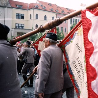 Group carrying historical communist banner during parade.