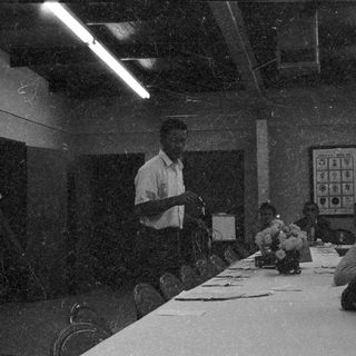 Classroom lecture with teacher and seated students.