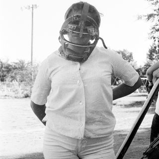 Baseball catcher wearing protective mask and gear.