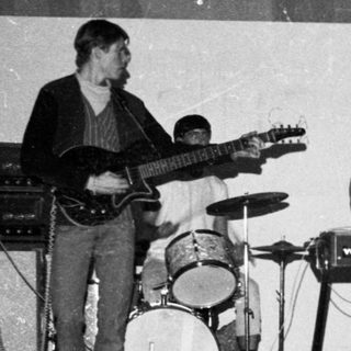 Band performing live with young boy watching.