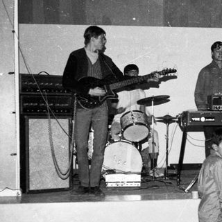 Band performing live with young boy watching.