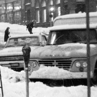 Winter street scene with man clearing snow.