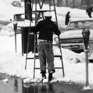 Winter street scene with man clearing snow.