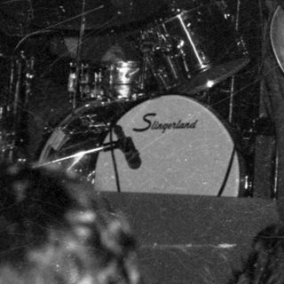 Live band performance with drummer and guitarist on stage.