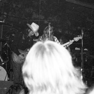 Live band performance with drummer and guitarist on stage.