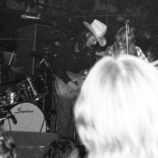 Live band performance with drummer and guitarist on stage.