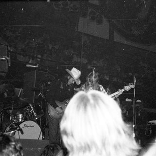 Live band performance with drummer and guitarist on stage.
