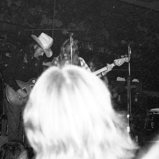 Live band performance with drummer and guitarist on stage.