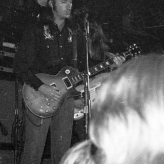 Live country musician performing guitar on stage.