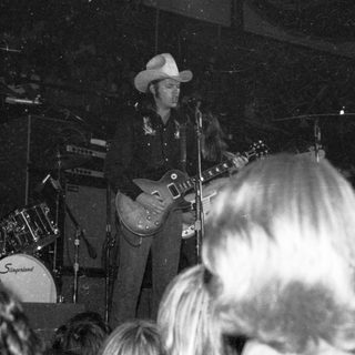 Live country musician performing guitar on stage.