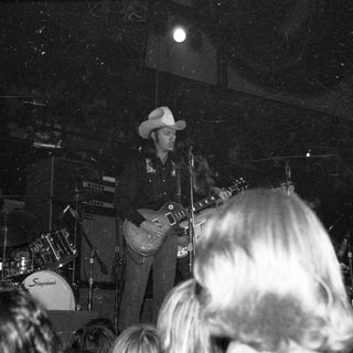 Live country musician performing guitar on stage.