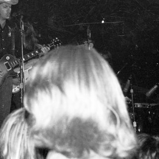 Live country musician performing guitar on stage.