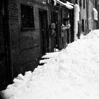 Heavy snow accumulation on city street.