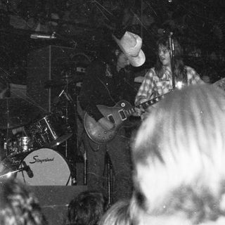 Live band performing with guitarist and drummer.