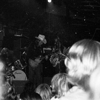 Live band performing on stage with audience.
