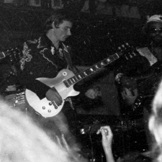 Live band performing on stage with audience.