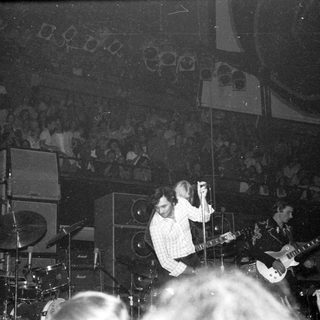 Live band performing on stage with audience.
