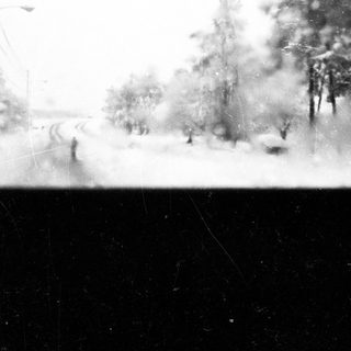 Snowy landscape with blurred figures walking outside.