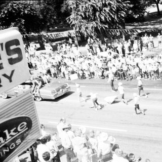 Crowded street scene with people running during event.