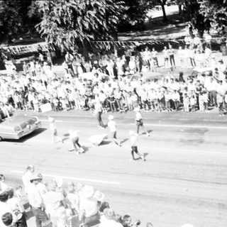 Crowded street scene with people running during event.