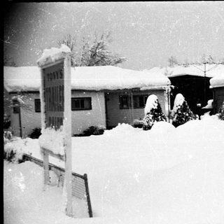 Snow-covered small-town businesses and buildings.