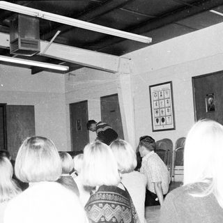 Group gathering in indoor meeting or classroom setting.