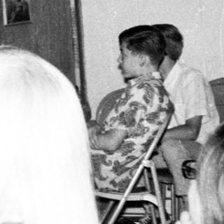 Group gathering in indoor meeting or classroom setting.
