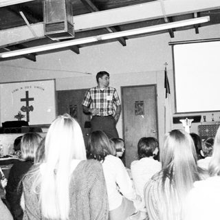 Classroom lecture with teacher addressing students.