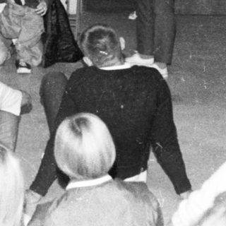School assembly with performer and students.