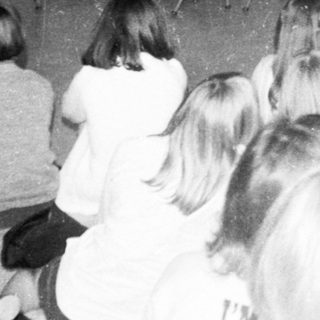 School assembly with performer and students.