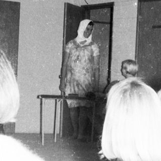 People attending a traditional cultural performance indoors.